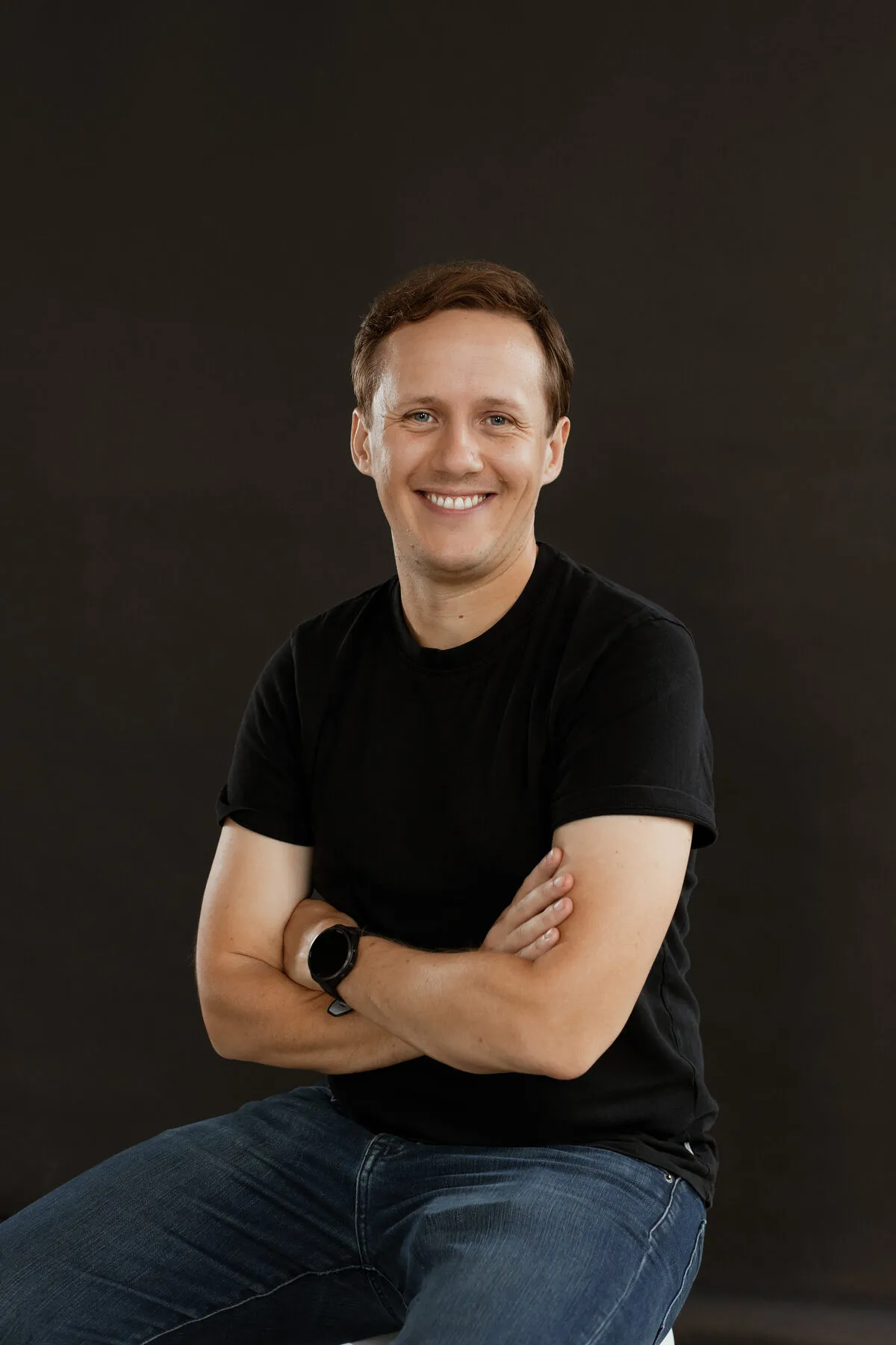 Connor Finlayson, smiling, seated with arms crossed.
